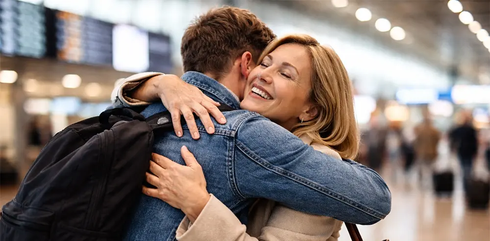 مادری در حال در آغوش گرفتن پسر جوان خود در فرودگاه کانادا پس از جدایی طولانی